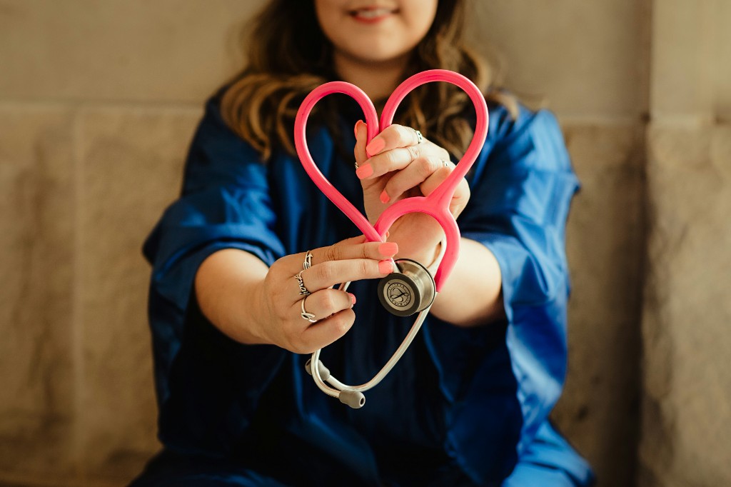 Healthcare professional holding a stethoscope shaped into a heart